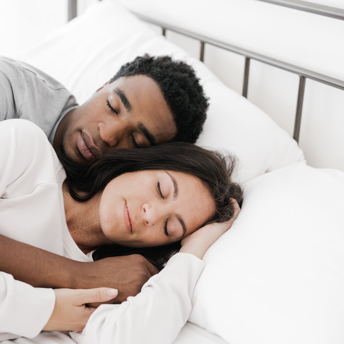 couple lay together on silk pillows
